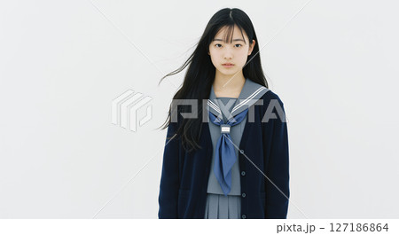 白背景。紺のカーディガンを着た髪がなびく女子高生 白背景。紺のカーディガンを着た髪がなびく女子高生 127186864