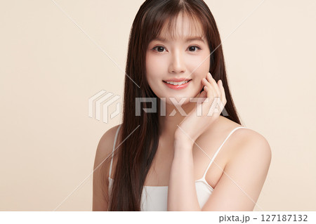 A beautiful young Asian woman with clean, fresh skin against a beige background. Skincare, facial treatment, cosmetology, beauty, and spa. An elegant portrait of an Asian woman. A beautiful young Asian woman with clean, fresh skin against a beige background. Skincare, facial treatment, cosmetology, beauty, and spa. An elegant portrait of an Asian woman. 127187132