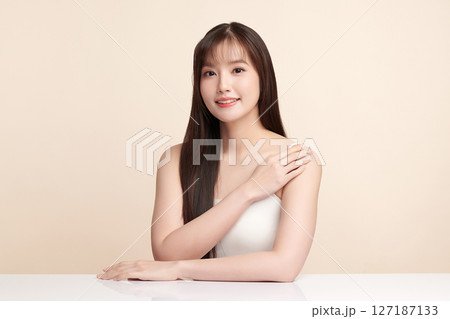 A beautiful young Asian woman with clean, fresh skin against a beige background. Skincare, facial treatment, cosmetology, beauty, and spa. An elegant portrait of an Asian woman. A beautiful young Asian woman with clean, fresh skin against a beige background. Skincare, facial treatment, cosmetology, beauty, and spa. An elegant portrait of an Asian woman. 127187133