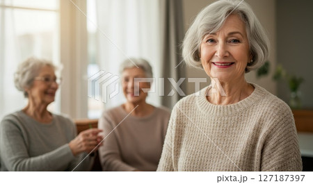 Happy Retired White Women of European Descent Socializing in Senior Community Lounge Wearing Cozy Sweaters 127187397
