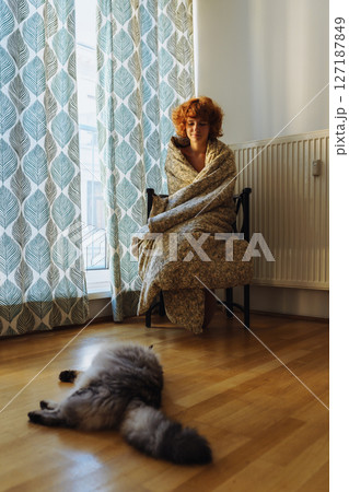 Girl hugging cat, sitting in blanket at home, frozen Girl hugging cat, sitting in blanket at home, frozen 127187849