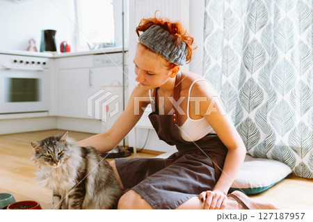 Caring for pet. teenage girl feeding domestic cat Caring for pet. teenage girl feeding domestic cat 127187957
