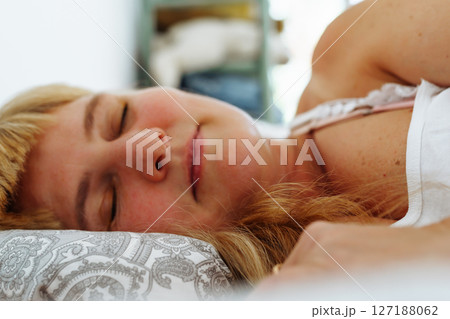 Attractive blonde woman waking up in bed Attractive blonde woman waking up in bed 127188062