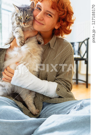 teenager with broken arm in cast and pet cat teenager with broken arm in cast and pet cat 127188170