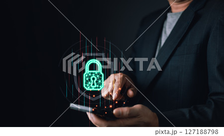 A person interacts with a smartphone, projecting a glowing digital lock symbolizing cyber protection. The futuristic interface highlights secure data, encryption, and online security measures. 127188798