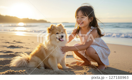海辺で犬と遊ぶ笑顔の女の子 127188963