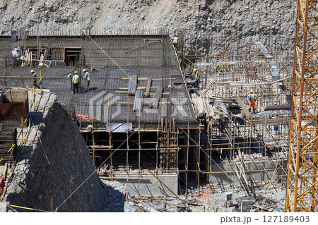 Workers in uniform at construction site build the underground floors of building 127189403