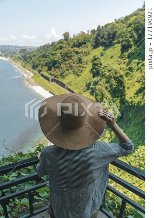 Female Explorer Looking at Ocean Horizon from Cliff 127190921