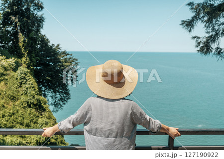Female Explorer Looking at Ocean Horizon from Cliff 127190922