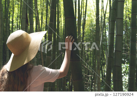 Girl in Straw Hat Exploring Bamboo Forest in Asia Girl in Straw Hat Exploring Bamboo Forest in Asia 127190924