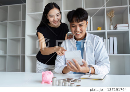 Happy young couple Checking Financial Documents And Calculating Budget At Home. paying taxes, saving money concept 127191764