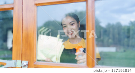 Woman doing household chores and wiping windows in the house on weekends Woman doing household chores and wiping windows in the house on weekends 127191814