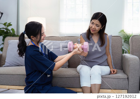 Asian female doctor advice elderly patient to physiotherapist to exercise at home Asian female doctor advice elderly patient to physiotherapist to exercise at home 127192012