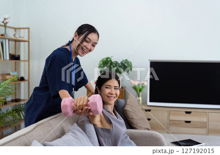 Asian female doctor advice elderly patient to physiotherapist to exercise at home 127192015