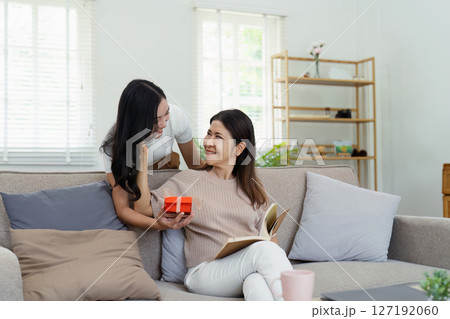 Congratulations. Loving asian mature daughter surprised mother with present in Mother's Day, giving her handmade card and gift box Congratulations. Loving asian mature daughter surprised mother with present in Mother's Day, giving her handmade card and gift box 127192060
