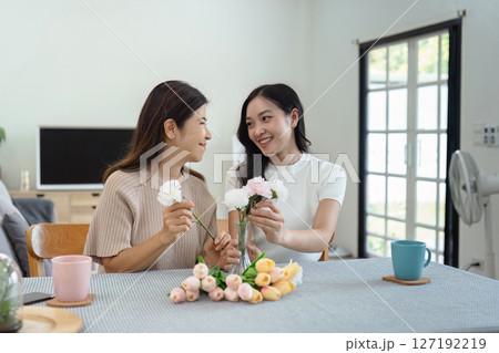 Mother and daughter arrange flower together at home on the weekend, family activities, mother and daughter do activities together on Mother's Day Mother and daughter arrange flower together at home on the weekend, family activities, mother and daughter do activities together on Mother's Day 127192219