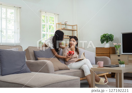 Congratulations. Loving asian mature daughter surprised mother with present in Mother's Day, giving her handmade card and gift box 127192221