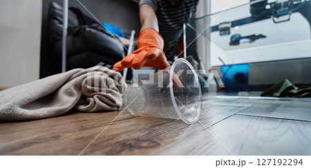housekeeper is cleaning up the messy house after the party. The housekeeper wife clean house on weekend housekeeper is cleaning up the messy house after the party. The housekeeper wife clean house on weekend 127192294