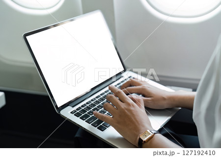 Business travel: Professional woman typing on a laptop in flight 127192410