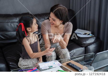 business woman work from home and take care of her child while working, doing activities with her child while working 127192418