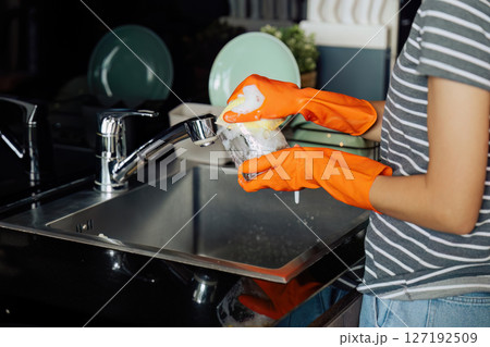 housewife cleans the house and washes the dishes at the sink. Cleaning home concept housewife cleans the house and washes the dishes at the sink. Cleaning home concept 127192509