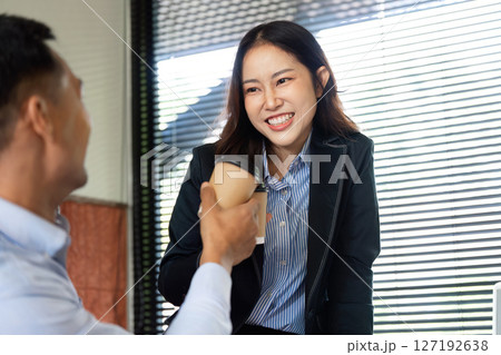 Professional Collaboration. Business partners sharing a joyful moment with coffee. 127192638