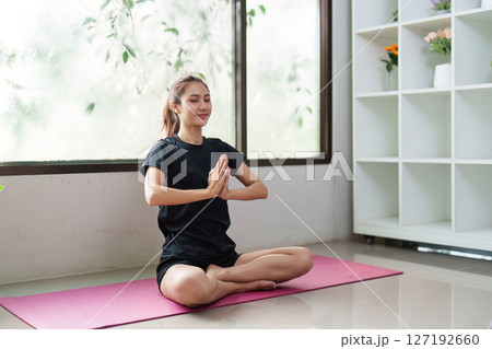 Mindfulness and Wellness. Young woman practicing yoga meditation indoors for relaxation and balance. Mindfulness and Wellness. Young woman practicing yoga meditation indoors for relaxation and balance. 127192660