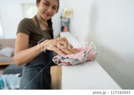 Cleaning with care: Woman dusting surfaces in the home 127192691