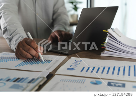 Paperwork report file with charts person working Paperwork report file with charts person working 127194299