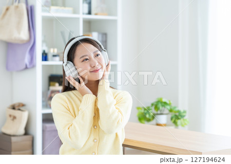 リビングで音楽を聴く若い女性 リビングで音楽を聴く若い女性 127194624
