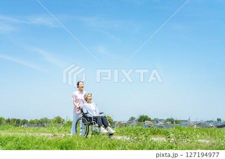 車椅子を押す介護士 127194977