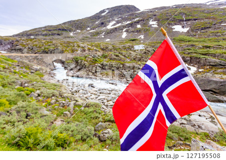 Norwegian flag and camper car in mountains 127195508