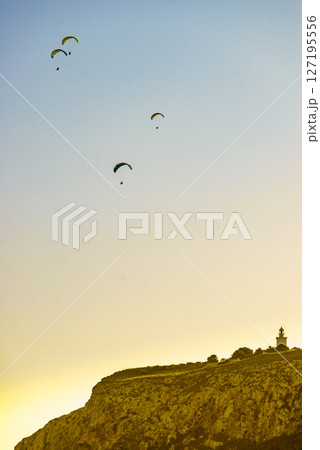 Paragliders flying in sky. Paragliders flying in sky. 127195556