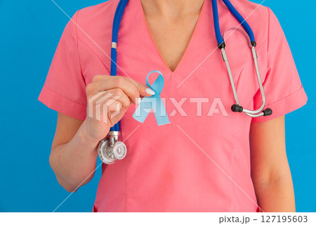 Doctor hands holding blue ribbon, diabetes and Colorectal Cancer Awareness 127195603