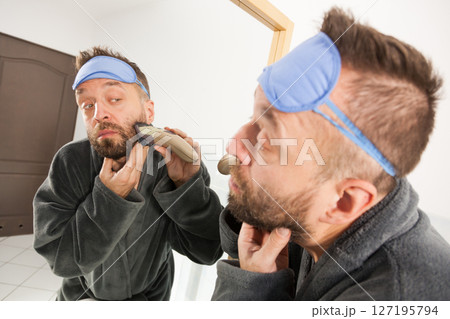 Man shaving trimming his beard Man shaving trimming his beard 127195794