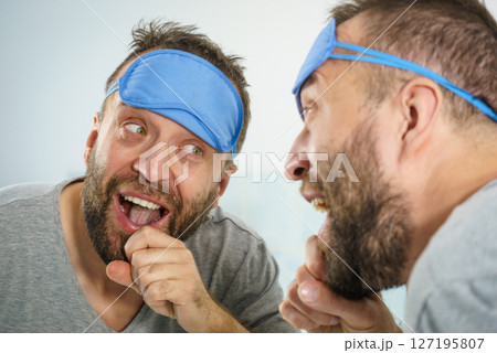 Happy man after sleep looking at mirror Happy man after sleep looking at mirror 127195807