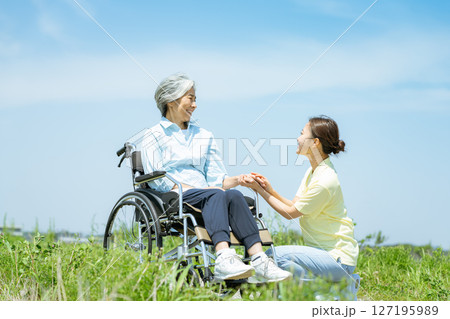 車椅子のシニアと介護士 車椅子のシニアと介護士 127195989