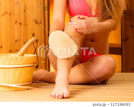 Young woman in sauna with glove 127196091
