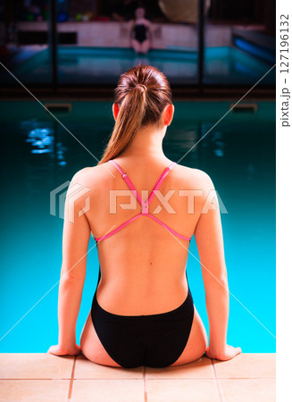 Girl swimmer muscular body in swimsuit at poolside Girl swimmer muscular body in swimsuit at poolside 127196132