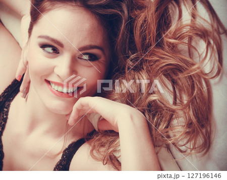 Portrait of happy young woman in lingerie in bed. Portrait of happy young woman in lingerie in bed. 127196146