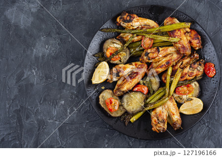 Baked chicken wings with asparagus and eggplant. Baked chicken wings with asparagus and eggplant. 127196166
