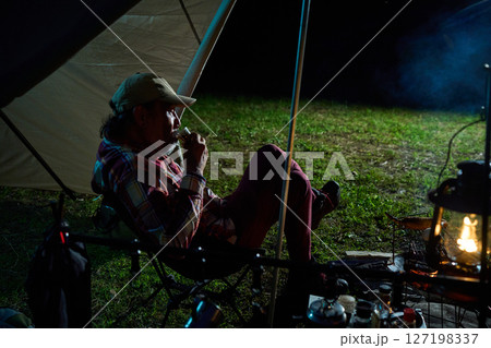 お酒を飲むソロキャンパー　ソロキャンプ　シニア 127198337