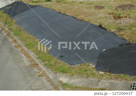 空地の法面に防草シートを敷いた様子 127200437