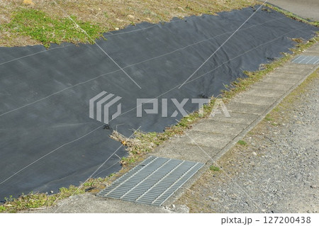 空地の法面に防草シートを敷いた様子 127200438