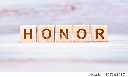 The HONOR concept word is assembled from wooden cubes. ethics, respect, code, honesty, integrity concept 127203017