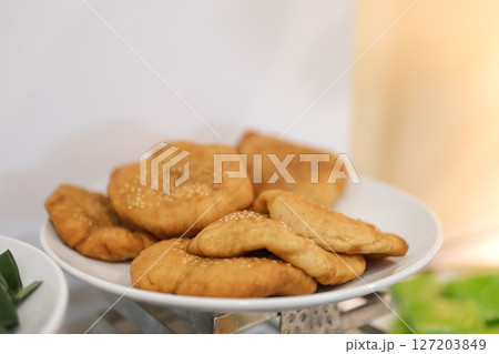 belyash plate with ready-made baked meat pies, a plate with baked pies rotates in a circle. 127203849