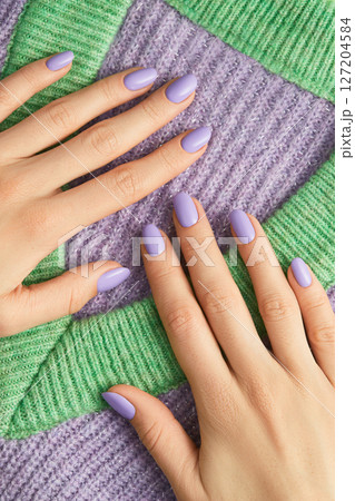 Beautiful womans hands on sweeter with purple fashionable spring nail design 127204584