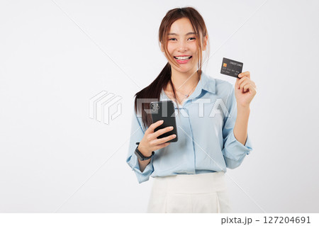 Happy asian woman holds mobile phone, uses a credit card, banks online, shops, and displays a payment card. isolated studio white background Happy asian woman holds mobile phone, uses a credit card, banks online, shops, and displays a payment card. isolated studio white background 127204691