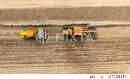 Aerial view motor grader civil at construction site, Motor grader work on construction site, Road grader on road construction site machine work on the construction of new road. 127205115