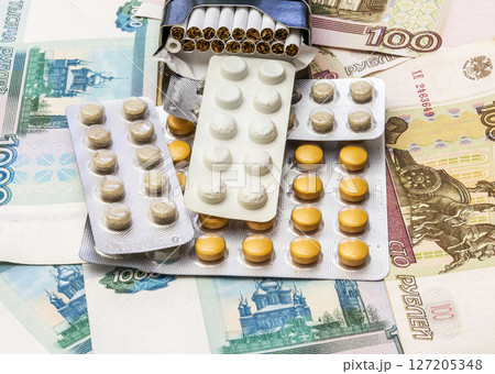 Cigarettes and medical drugs lie on banknotes 127205348